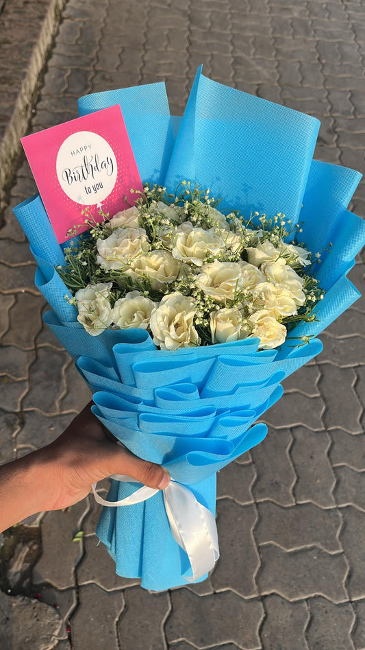 Bouquet of white flowers with a blue wrap and a pink card on a textured surface