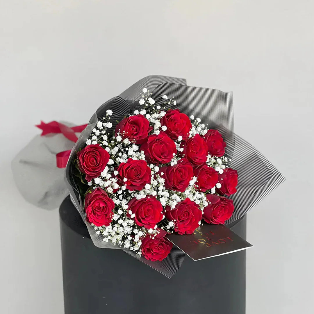 Bold Love bouquet close-up, red roses with satin ribbon