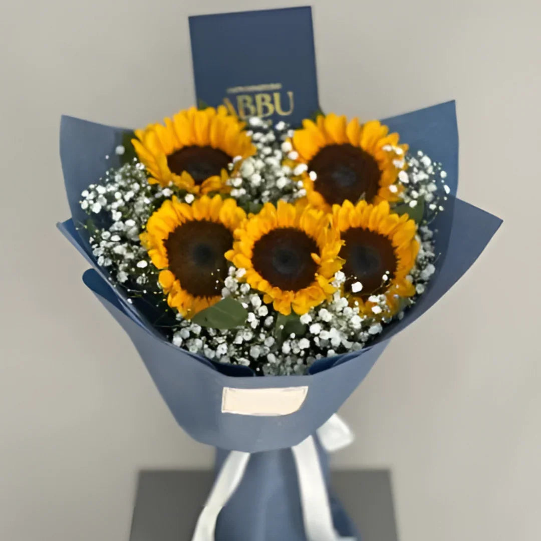 Cozy Radiance Bouquet featuring five fresh yellow sunflowers wrapped in matte slate blue paper by Flower House