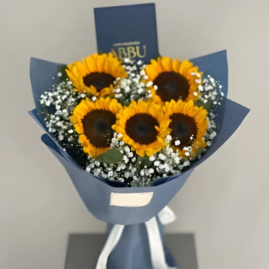 Cozy Radiance Bouquet featuring five fresh yellow sunflowers wrapped in matte slate blue paper by Flower House