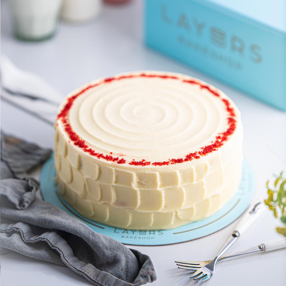 Authentic Layers Red Velvet Cake featuring rich cream cheese frosting on soft red velvet sponge cake layers