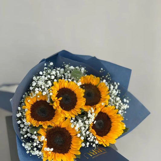 Radiant sunflower bouquet with dense baby's breath fillers and a dark blue Abbu greeting card
